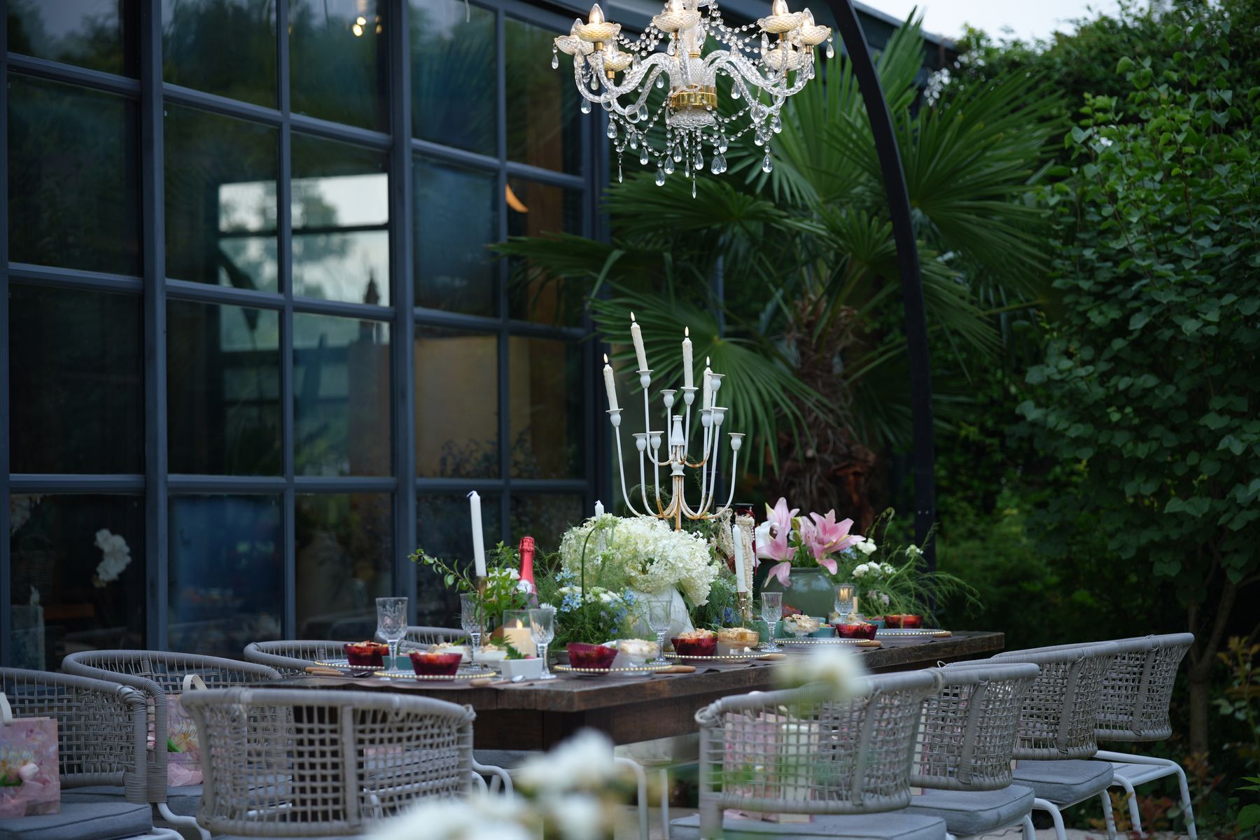 Dinner table under chandeliers in the greenery